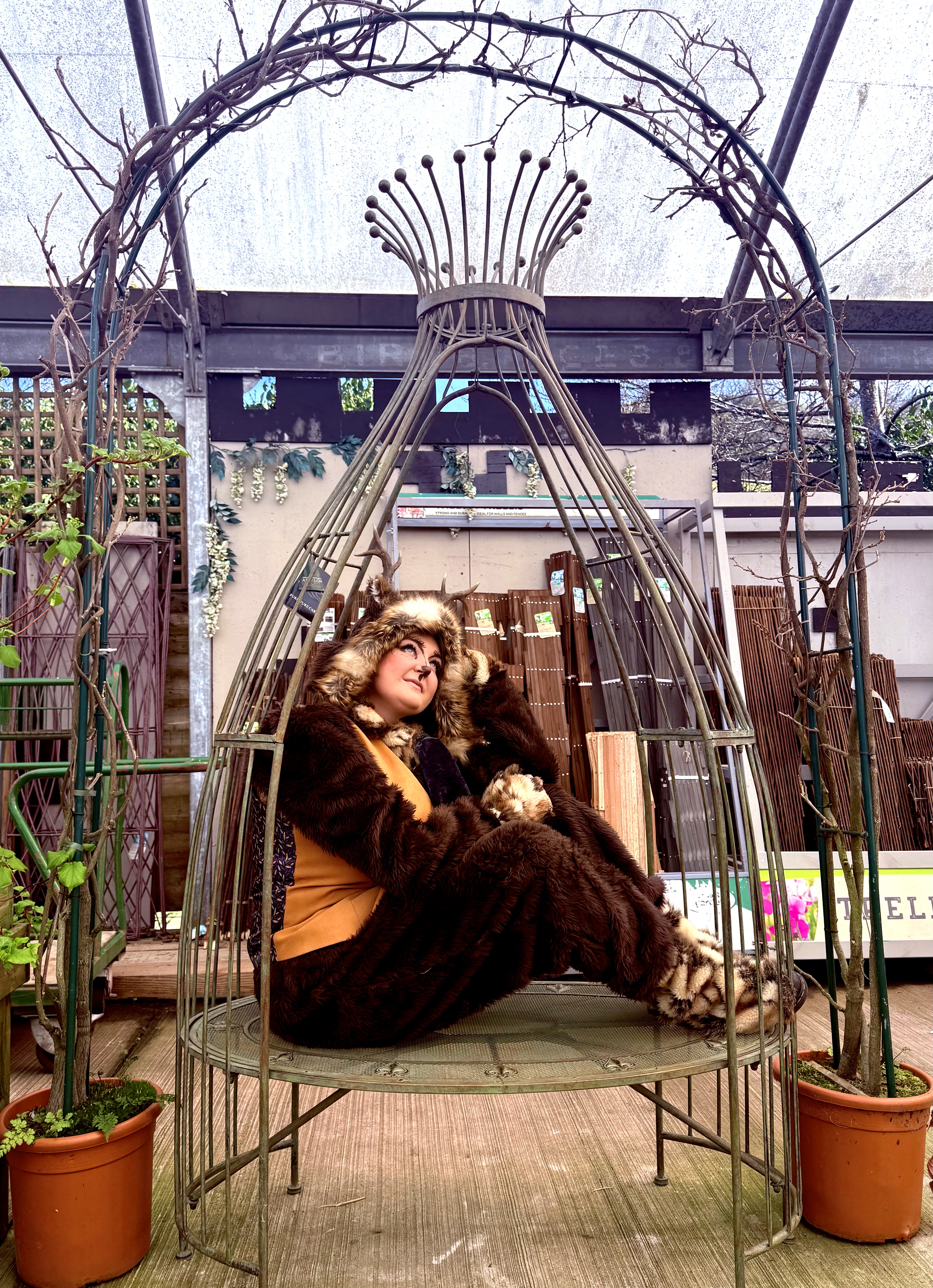 An antlered woodland character reclining in a domed garden pod chair
