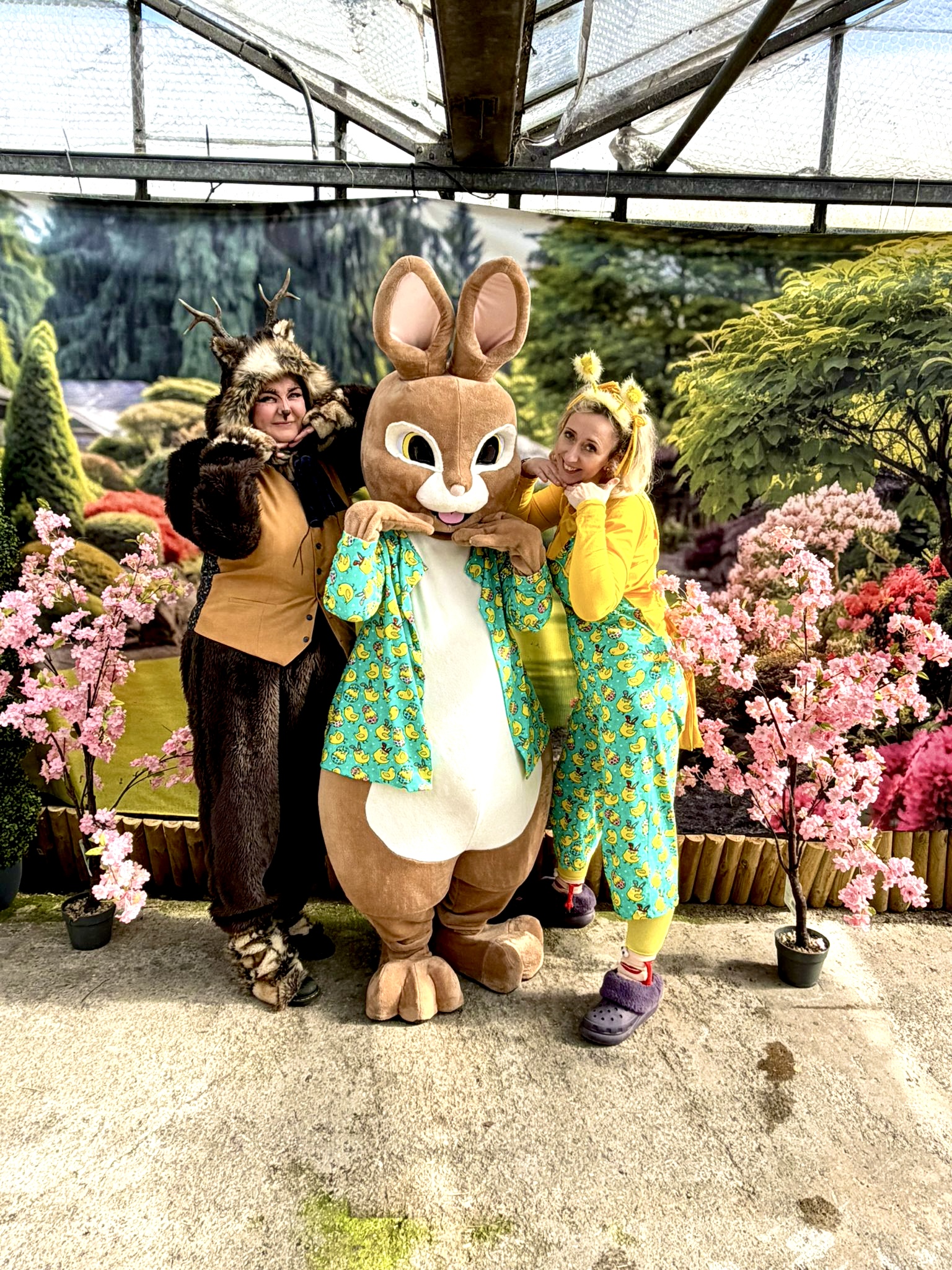 Three costumed characters together: a woodland creature, a giant rabbit and a duckling-print host